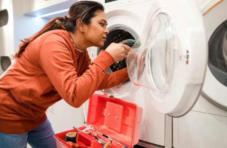 Woman troubleshooting a washing machine in a kitchen, highlighting laundry appliance repair services available in San Francisco, CA.