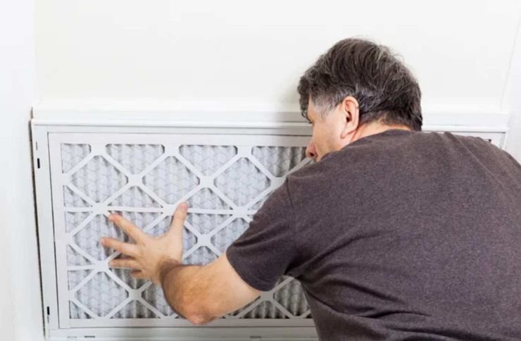 A man checks the air filter of a furnace, representing appliance repair services available in San Francisco, CA.