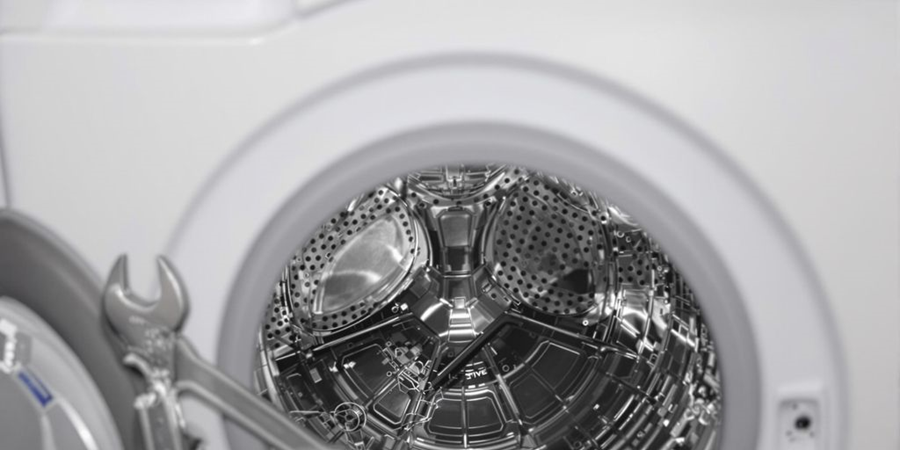 Close-up of a washing machine featuring a wrench resting on its surface, highlighting maintenance tools for appliance care. 
