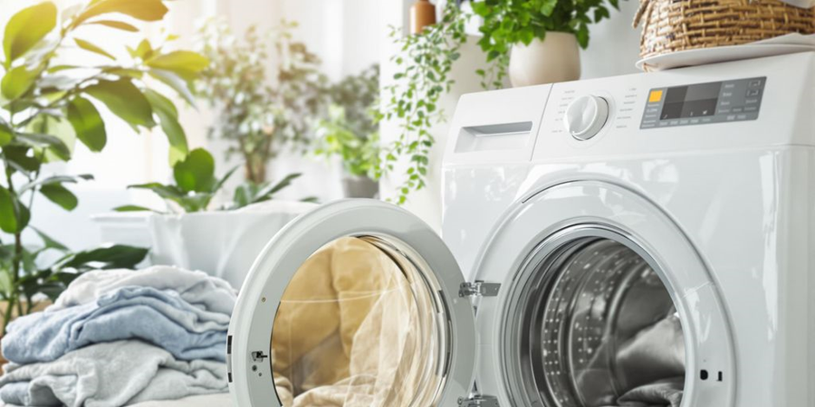  A washing machine filled with various clothes, ready for a wash cycle to begin.